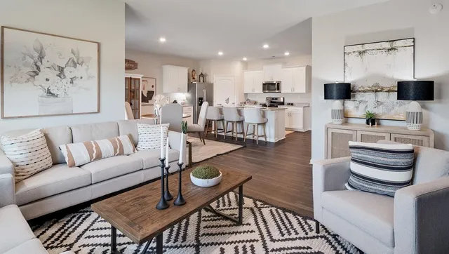 a living room with furniture a bookshelf and a large window