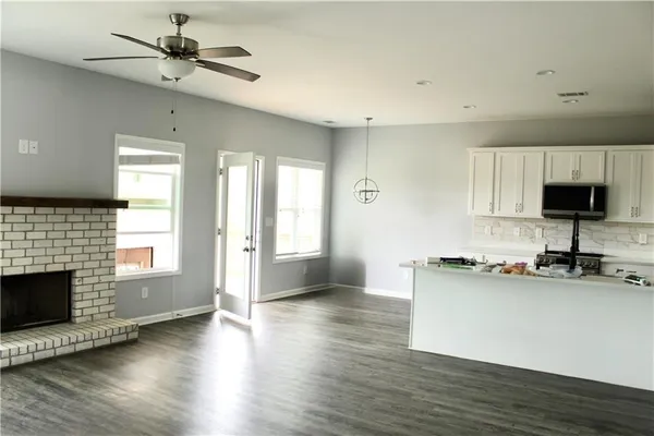 a kitchen with granite countertop a stove a sink and a microwave