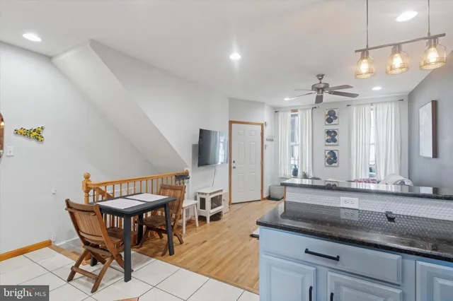 a spacious bathroom with a granite countertop sink a table and chairs