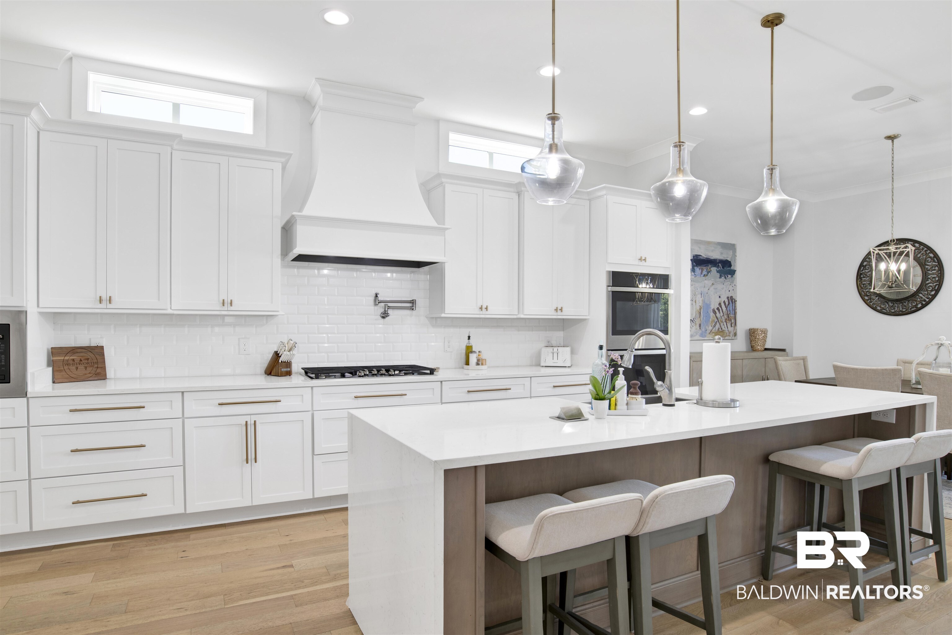 32937 River Road Orange Beach, AL 36561 - Photo 16 of 42 Kitchen featuring a kitchen island with sink, white cabinets, and custom exhaust hood