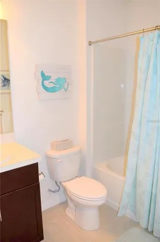 a white toilet sitting next to a bathroom sink and a shower