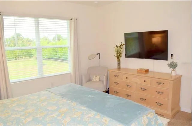 a bedroom with a bed and a flat screen tv