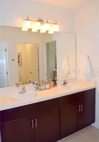 a bathroom with a double vanity sink and a mirror