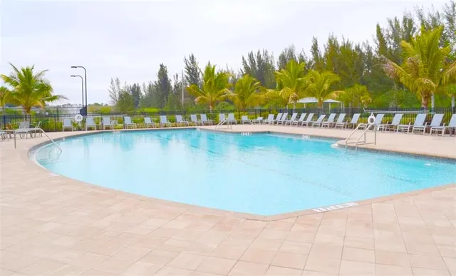 a view of a swimming pool with lawn chairs under an umbrella