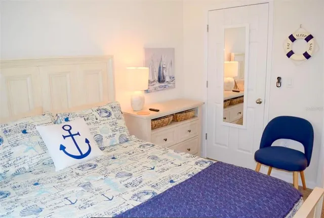 a bedroom with a bed and a chair with the view of bathroom