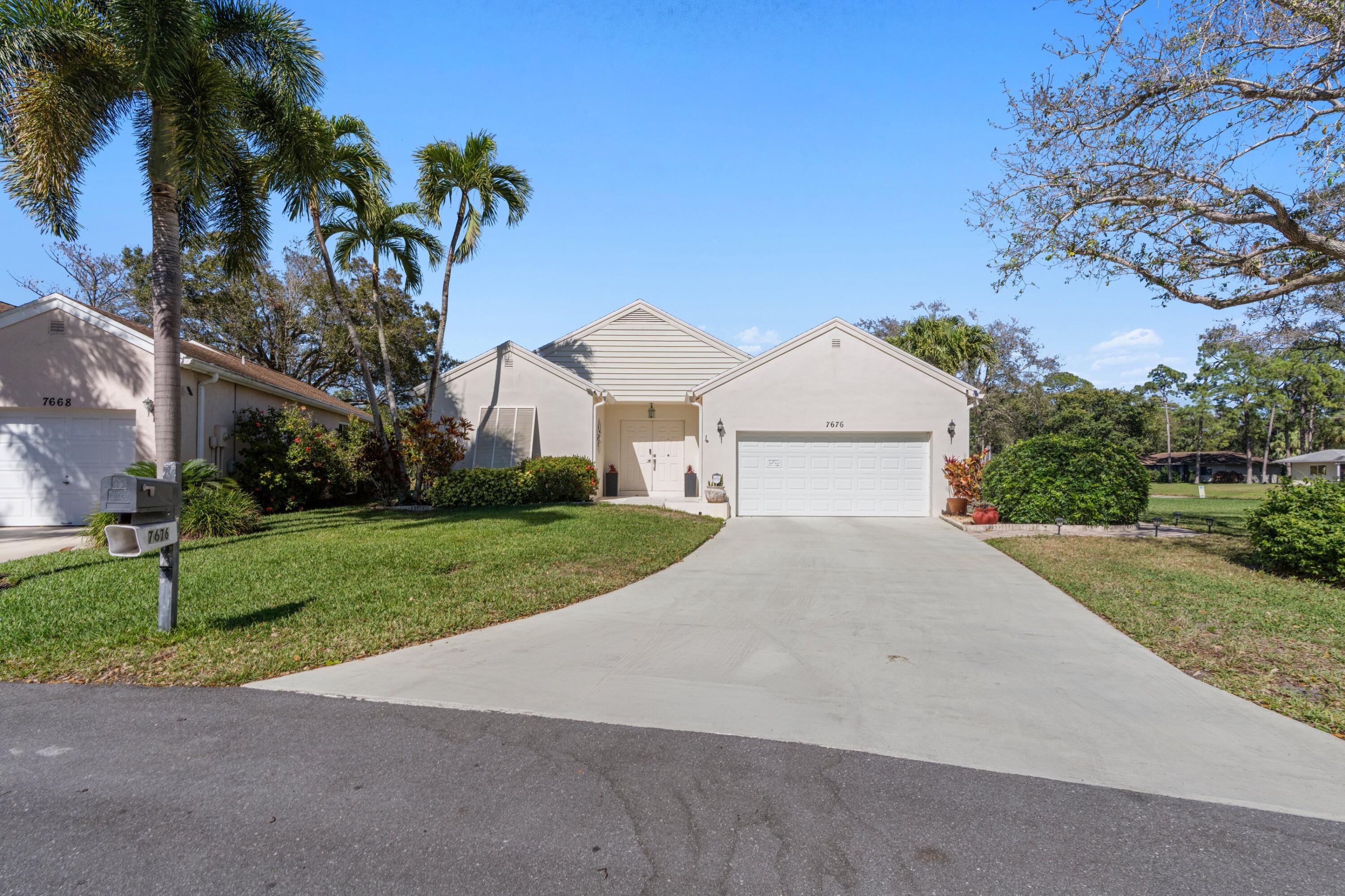 7676 Kings Ride Boynton Beach, FL 33436 - Photo 27 of 41 a view of a white house with a yard and palm trees