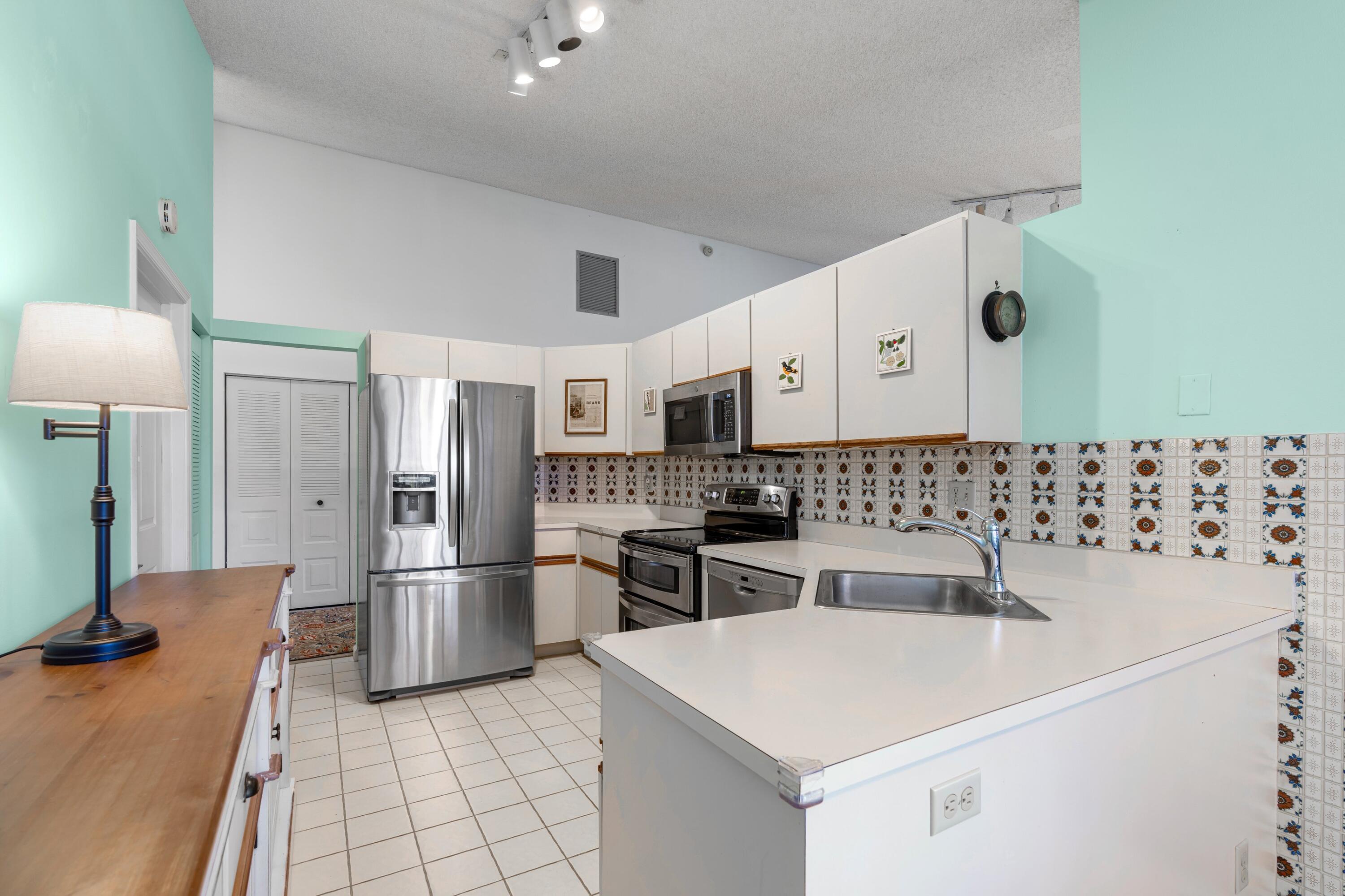 7676 Kings Ride Boynton Beach, FL 33436 - Photo 7 of 41 a kitchen with stainless steel appliances granite countertop a sink stove and refrigerator