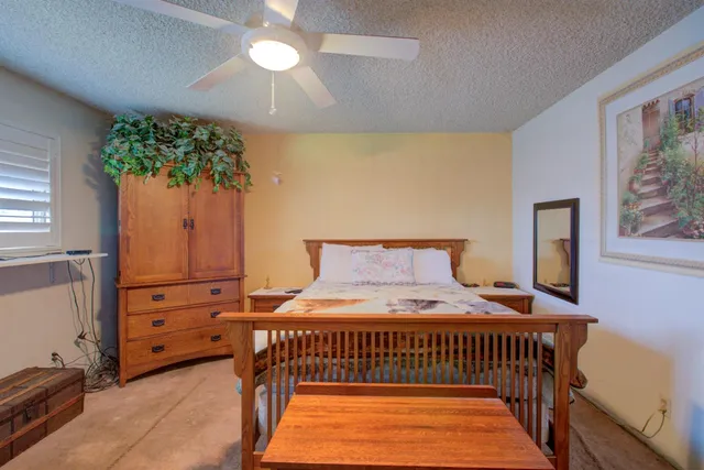 a kitchen with stainless steel appliances granite countertop a stove a sink dishwasher a refrigerator and white cabinets with wooden floor