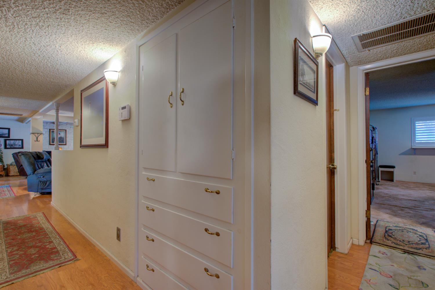 5900 Washington Road Turlock, CA 95382 - Photo 40 of 56 a view of a hallway with closet and a fireplace