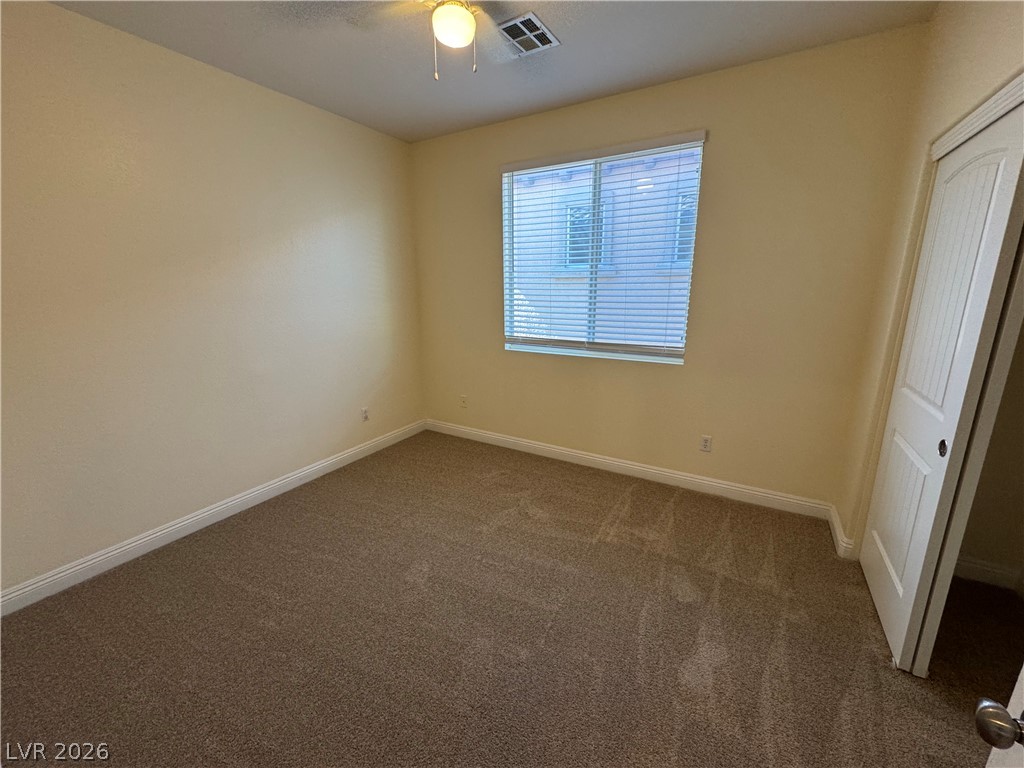 1333 Jamesbury Road Las Vegas, NV 89135 - Photo 28 of 43 A well-lit bedroom features plush carpeting and a convenient ceiling fan.
