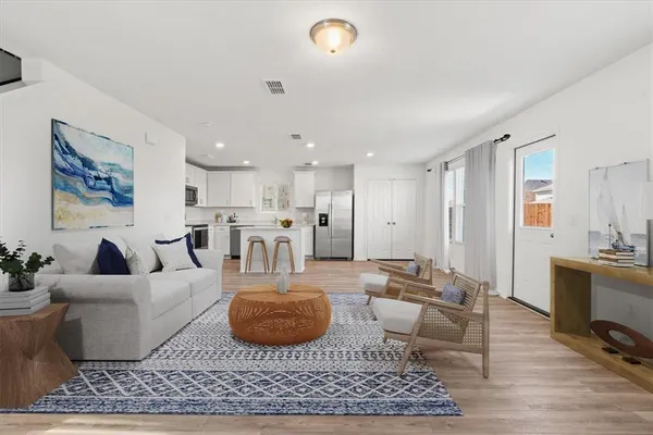 a living room with furniture kitchen view and a rug