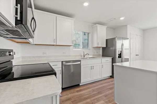 a kitchen with granite countertop a sink stove and refrigerator