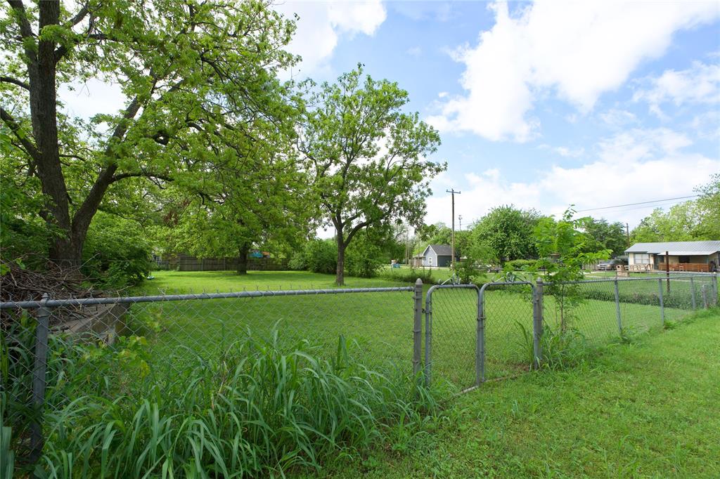 714 Potter Street Gainesville, TX 76240 - Photo 10 of 12 The property features a spacious yard with mature trees and a chain-link fence