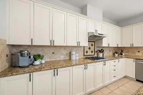a kitchen with granite countertop white cabinets and white appliances