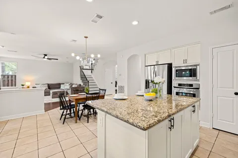 a kitchen with stainless steel appliances granite countertop dining table chairs and granite counter tops