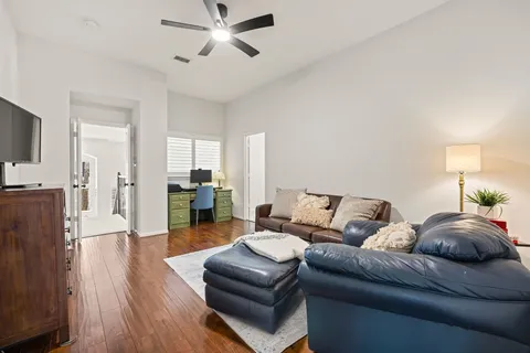 a living room with furniture and a wooden floor