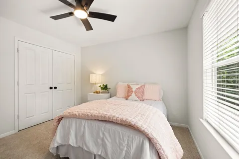 a bed sitting in a bedroom next to a window