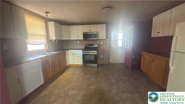a kitchen with stainless steel appliances granite countertop a refrigerator and a stove
