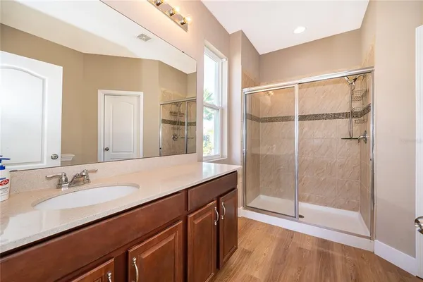 a bathroom with a double vanity sink a mirror and a shower