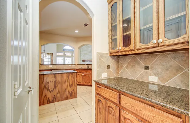 a kitchen with granite countertop a coffee maker on granite countertops and cabinets