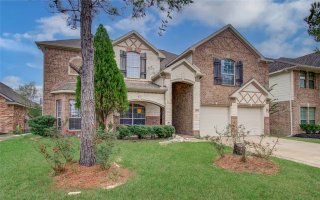 a front view of a house with a garden and plants