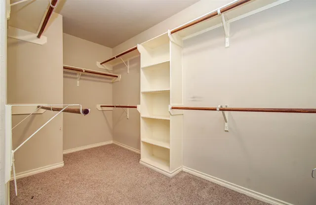 a view of an empty room with wooden floor and fence