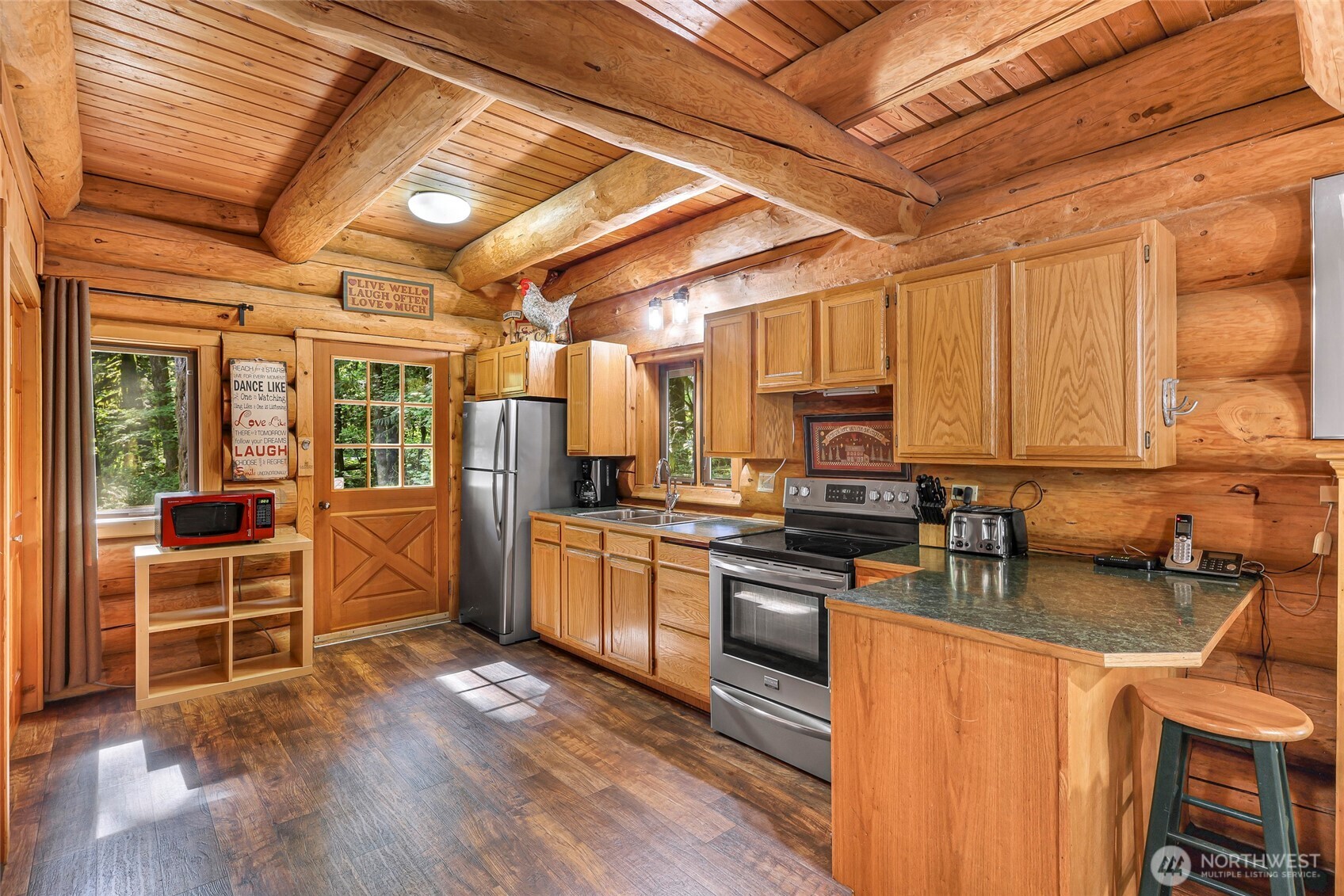7010 Rainier Way Deming, WA 98244 - Photo 11 of 35 a kitchen with stainless steel appliances granite countertop wooden floors a stove and a refrigerator