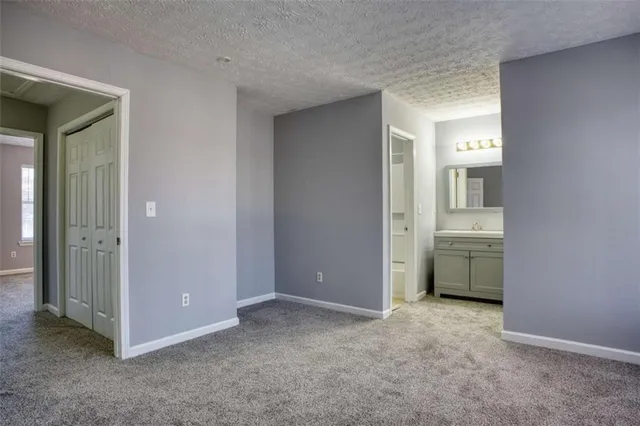 an empty room with windows & cabinet