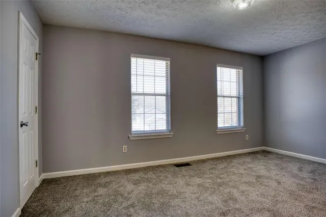 an empty room with closet and windows