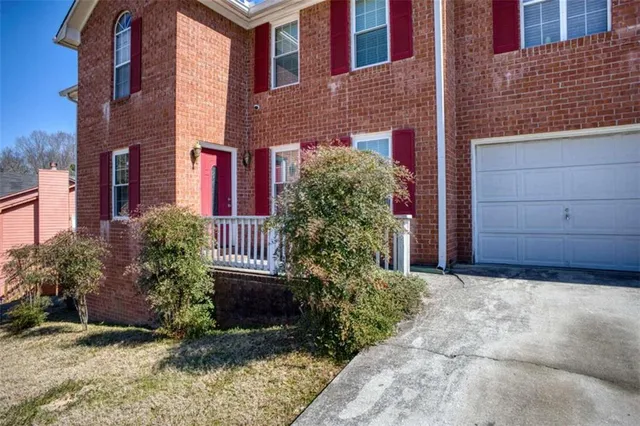 a view of a house with potted plants and wooden wall