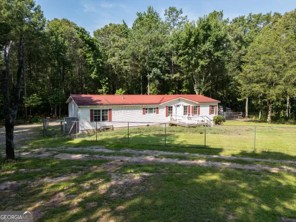 a backyard of a house with a yard and tree