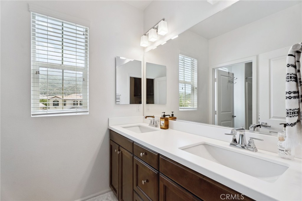 11266 Hutton Road Corona, CA 92883 - Photo 18 of 33 a bathroom with a double vanity sink and a mirror