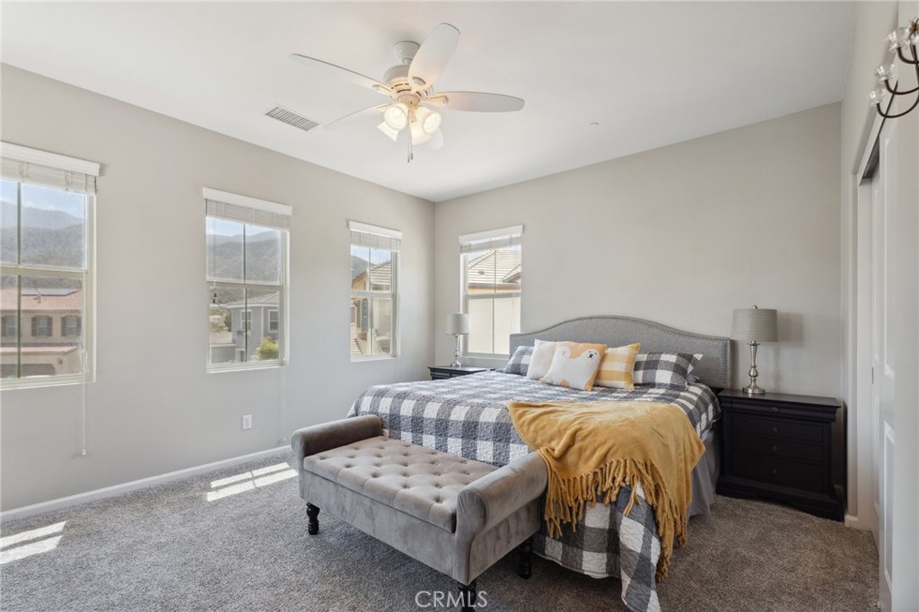 11266 Hutton Road Corona, CA 92883 - Photo 19 of 33 a spacious bedroom with a bed and a chandelier