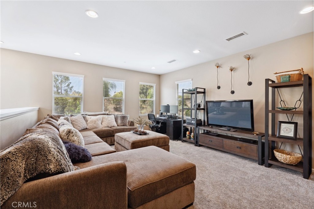 11266 Hutton Road Corona, CA 92883 - Photo 7 of 33 a living room with furniture gym equipment and a flat screen tv