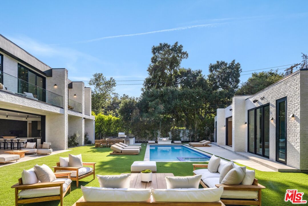 17055 Rancho Street Encino, CA 91316 - Photo 51 of 73 a view of a swimming pool with couches chairs and a fire pit