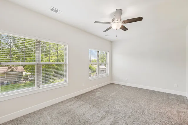 an empty room with fan and windows