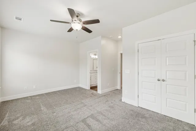 an empty room with ceiling fan and window