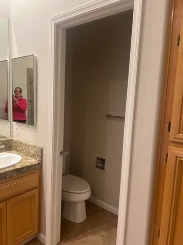 a bathroom with a toilet sink and mirror