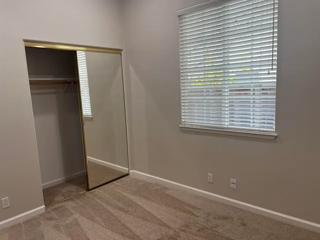 an empty room with windows and closet