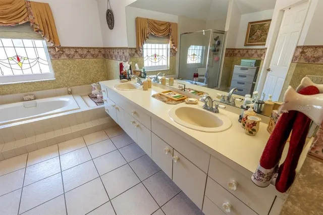 a spacious bathroom with a double vanity sink mirror and bathtub