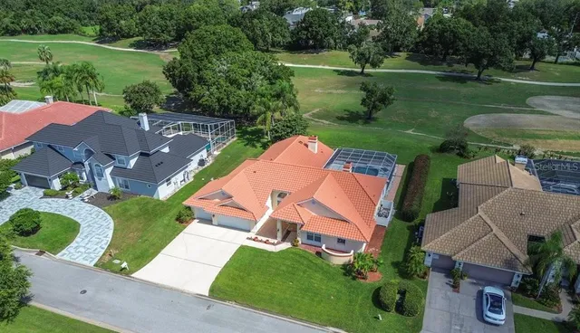an aerial view of a house with outdoor space lake view and a yard