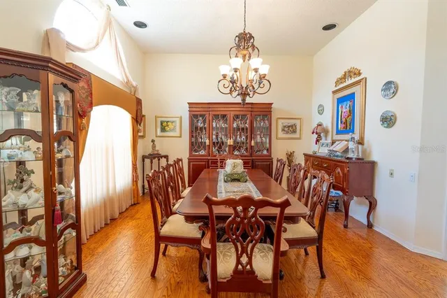 a view of a dining room with furniture a chandelier and wooden floor