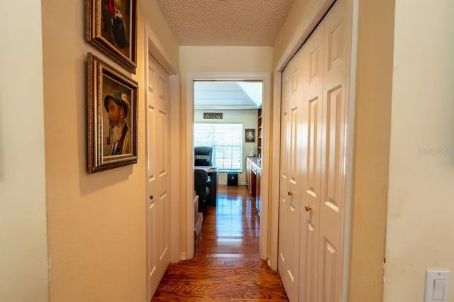 a view of a hallway with wooden floor and windows