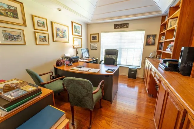 a view of a workspace with furniture and a window