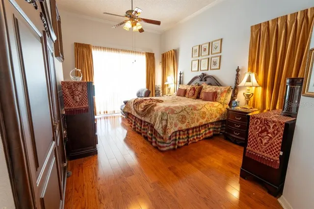a spacious bedroom with a bed and wooden floor