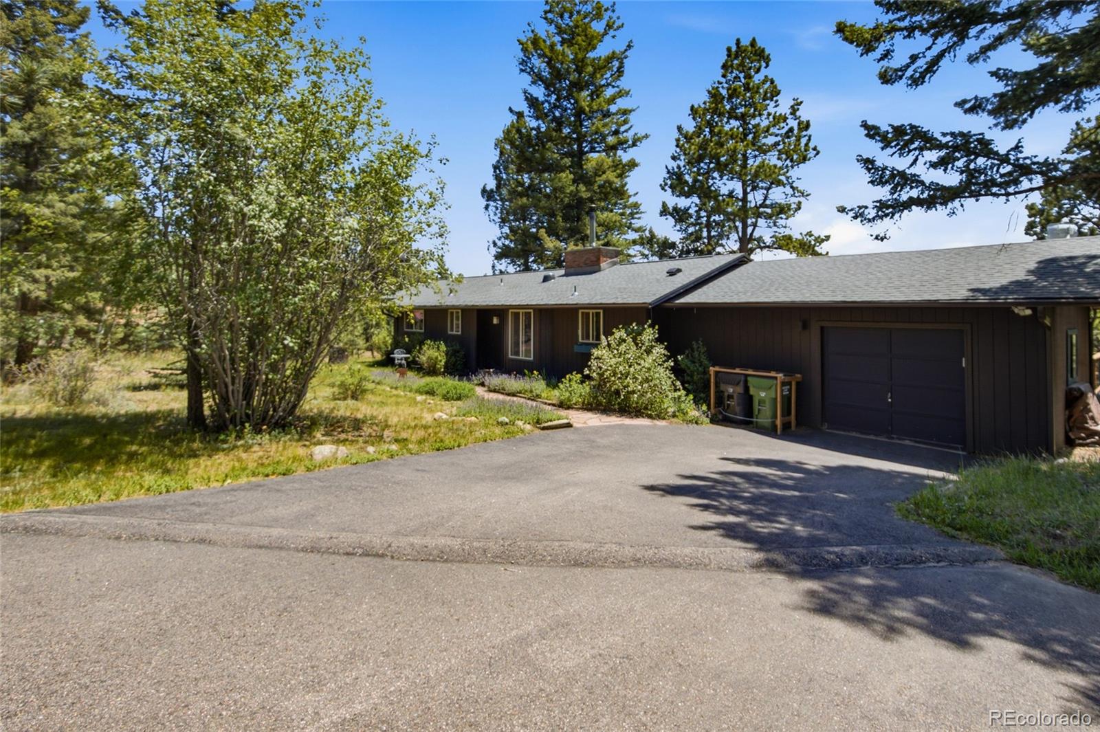 31280 Florence Road Conifer, CO 80433 - Photo 3 of 48 a front view of a house with a yard and garage