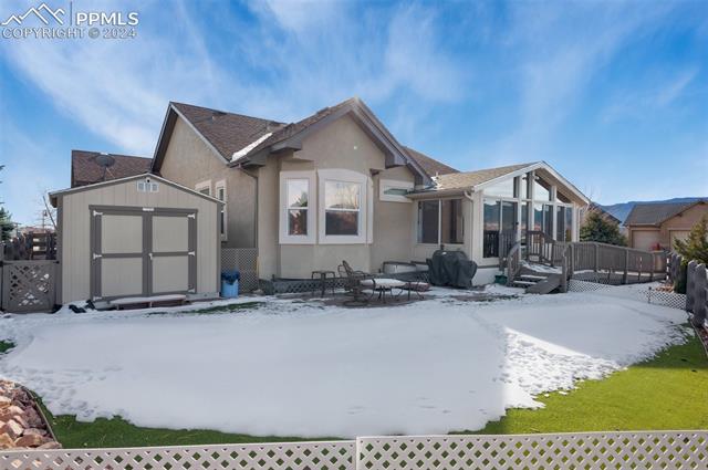 533 Talus Road Monument, CO 80132 - Photo 43 of 46 Snow covered rear of property featuring a deck, a storage shed, and a sunroom