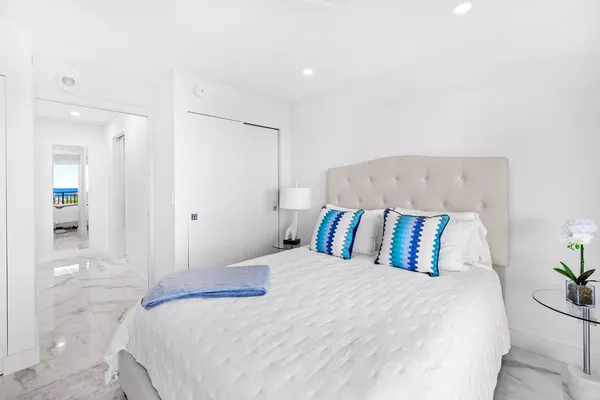 a bedroom with a large bed and a potted plant