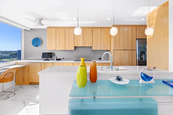 a kitchen with kitchen island granite countertop a sink a stove and wooden cabinets