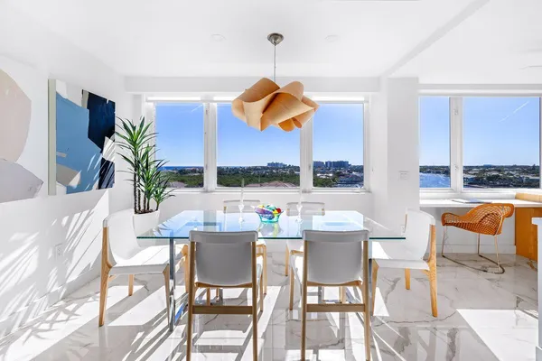 a kitchen with stainless steel appliances kitchen island granite countertop a table and a microwave